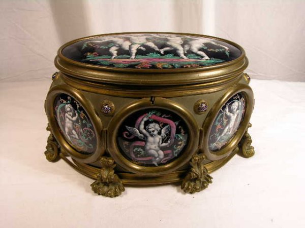 LARGE LIMOGES CASKET BOX WITH TUFFED LINING.: LARGE LIMOGES CASKET BOX WITH TUFFED LINING. SIX SEMI CIRCULAR AND ONE VERY LARGE PLAQUE ON LID. ALL PUTTI WITH GARLANDS AND BOWS. SUPPORTED ON SIX RAISED FOLIATE LEAVES. (TOP HAS 1/2" SCRATCH;VERY EA