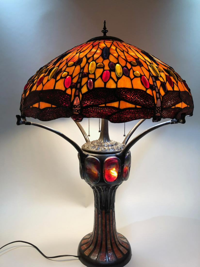 Large Tiffany Studios style glass and bronze three: Large Tiffany Studios style glass and bronze three light lamp. CIrca 1980. Overall height 33 inches. (The top metal has a dingand cracks, the glass has some cracks, see photos).
