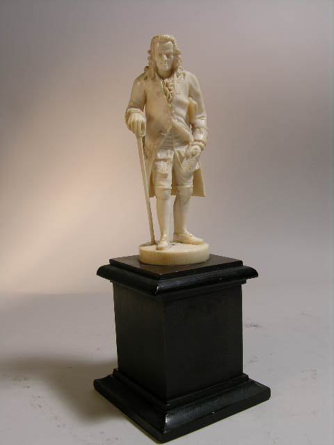EUROPEAN CARVED IVORY FIGURE OF VOLTAIRE WITH A CAN