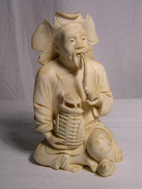 IVORY CARVING OF A MAN WITH A PIPE AND A TURTLE ON