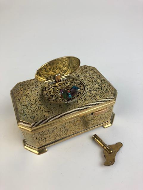 Mechanic singing bird box with a Karl Greisbaum: Mechanic singing bird box, black enamel with a foliate design. Circa 1930 with a Karl Greisbaum movement. When the slid bar is slid to the right the lid raises and a small bird with flapping wings twe