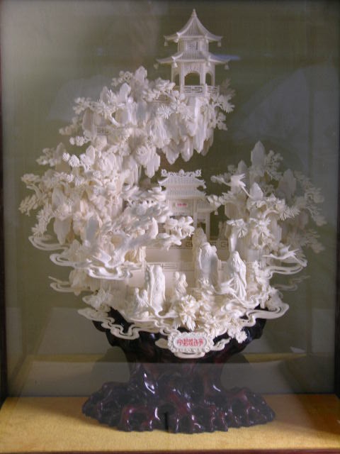 CHINESE IVORY CARVING OF A FORREST.: CHINESE IVORY CARVING OF A FORREST. A MAGNIFICENT CARVING OF MANY FIGURES, TREES AND POGADOS. HEIGHT OF CAVING ON ITS WOOD STAND 24" X 18". WITH A CUSTOM MADE VIEWING GLASS BOX AND CARRY CASE. INTERNA