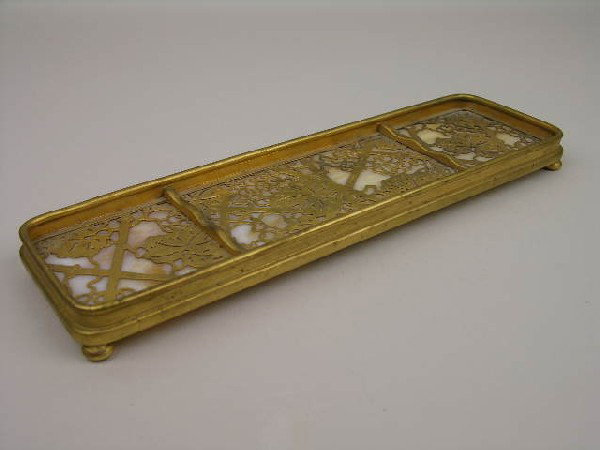 TIFFANY STUDIOS GRAPEVINE PEN TRAY.: TIFFANY STUDIOS PEN TRAY IN THE GRAPEVINE PATTERN WITH CAMEL COLORD COLOR GLASS AND SUPPORTED ON FOUR SMALL BUNN FEET. PROPERLY STAMPED "TIFFANY STUDIOS NEW YORK 1004". LENGTH 9 1/2". CIRCA 1920.