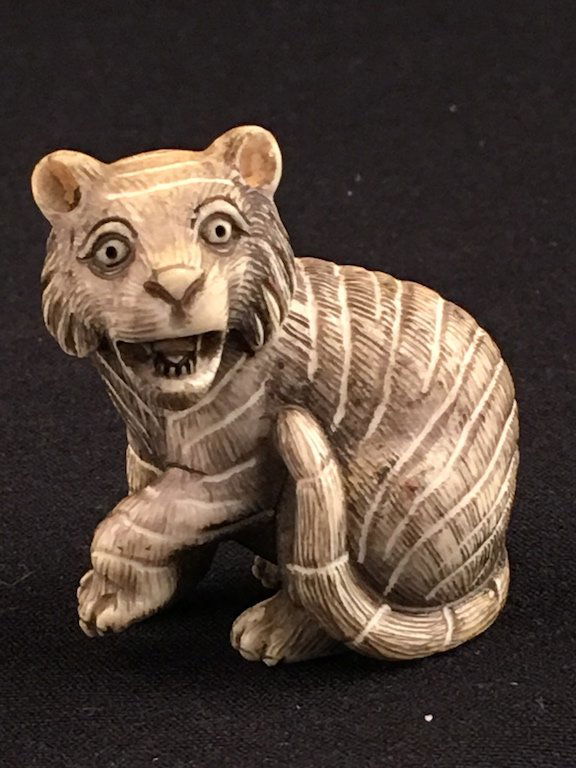 Japanese antique carved  Netsuke monochromed figure of a sitting lion. Artist signed. (1 of 3)