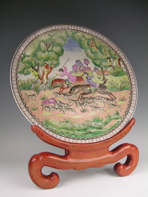 CHINESE QIANLONG 18 TH CENTURY JARDINAIRE.: CHINESE QIANLONG 18 TH CENTURY CHARGER WITH AN ENAMELLED PORCELAIN CHARGER DECORATED WITH A HUNTING SCENE WITH DOGS AND TWO HUNTERS ON HORSEBACK, WITH A WOOD DISPLAY STAND. THE BOTTOM OF THE CHARGER W