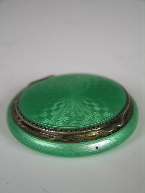 SILVER AND ENAMELED COMPACT.: A SILVER AND GREEN ENAMELED COMPACT. DIAMETER 2 1/8".