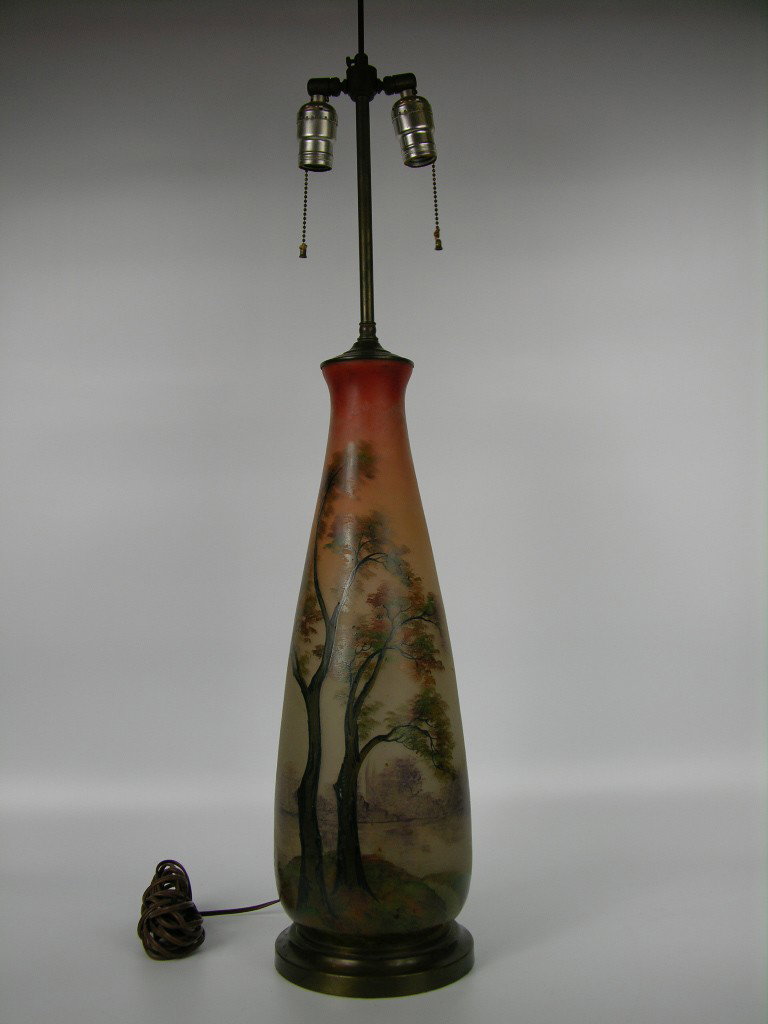 LEUNE/DAUM ENAMELLED FRENCH TABLE LAMP.: CIRCA 1930 LEUNE/DAUM ENAMELLED FRENCH TABLE LAMP WITH PAINTED SCENES OF TREES AND GRASSES. SIGNED "LEUNE". OVERALL HEIGTH 38 1/2".