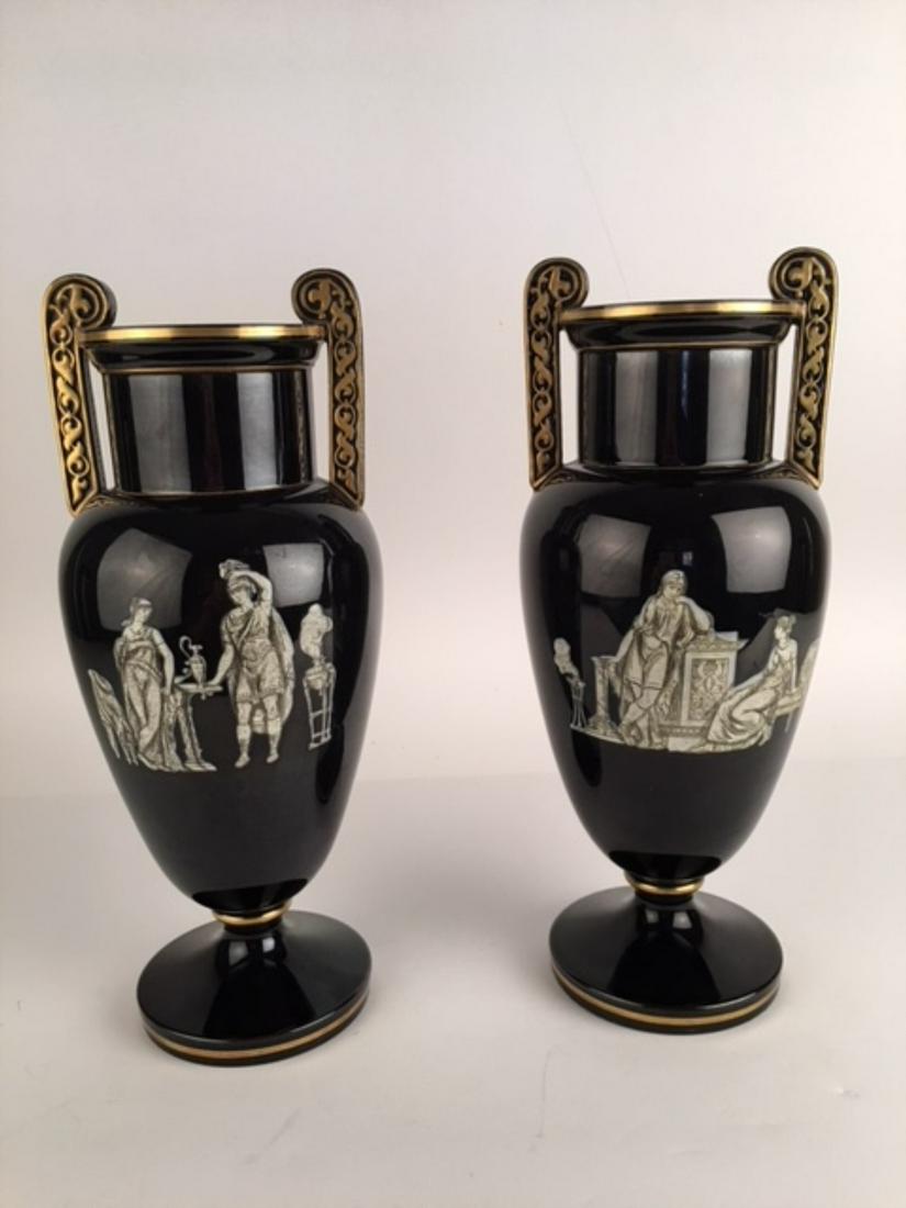 A French pair of opaline glass vases with romantic scenes on each side a: A French pair of opaline glass vases with romantic scenes on each side and attached handles.Overall height 13 1/4 inches.(These have been drilled to use as lamps).