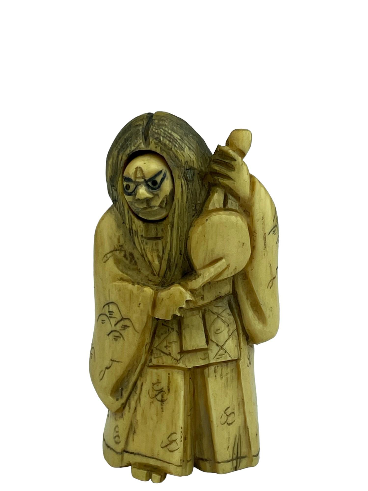 Antique Japanese carved netsuke figure of a standing man holding and beating a d (1 of 6)