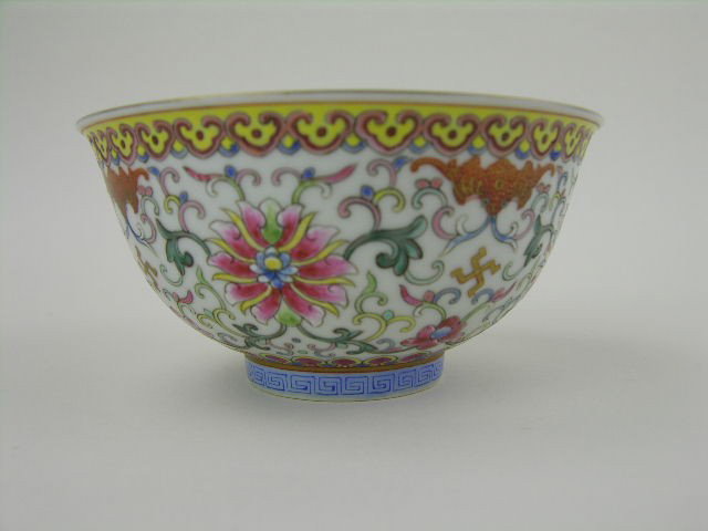 Chinese famille rose porcelain bowl enameled with : Chinese famille rose porcelain bowl enameled with lotus scrolls and bats, the yellow ground rim with clouds, the foot with fretwork, six-character Qianlong mark. H: 2 ¼" Diameter: 4 5/8"