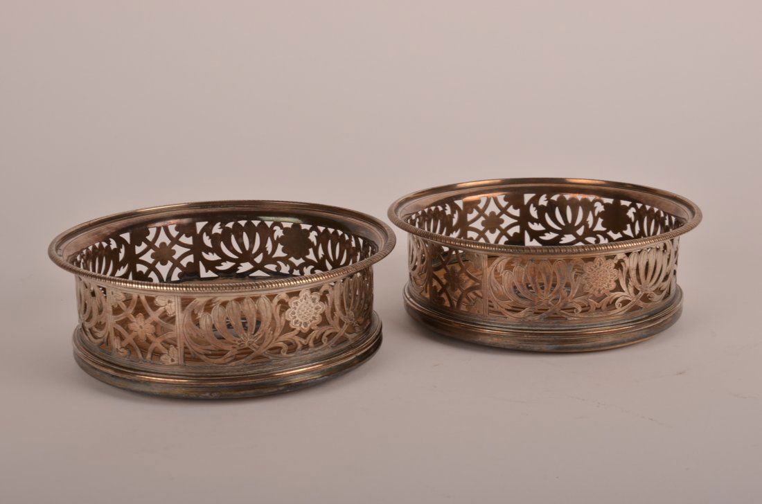 A Pair of Peter and Ann Bateman George III: A Pair of George III Sterling Silver reticulated Wine Coasters by Peter and Ann Bateman, London, 1801, circular with pierced leaves, engraved flowers, wood liners. Height: 2" Diameter: 5 1/2"