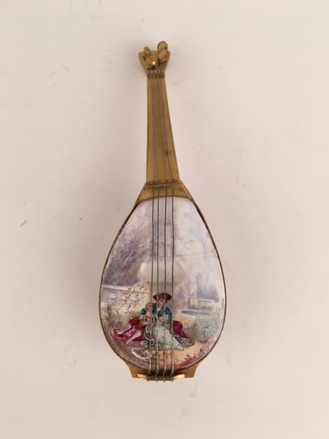 Austrian Viennese enamel pill box in the shape of a mandolin: Austrian Viennese enamel painted pill box in the shape of a mandolin painted with a romantic scene.Length 5 7/8 inches.