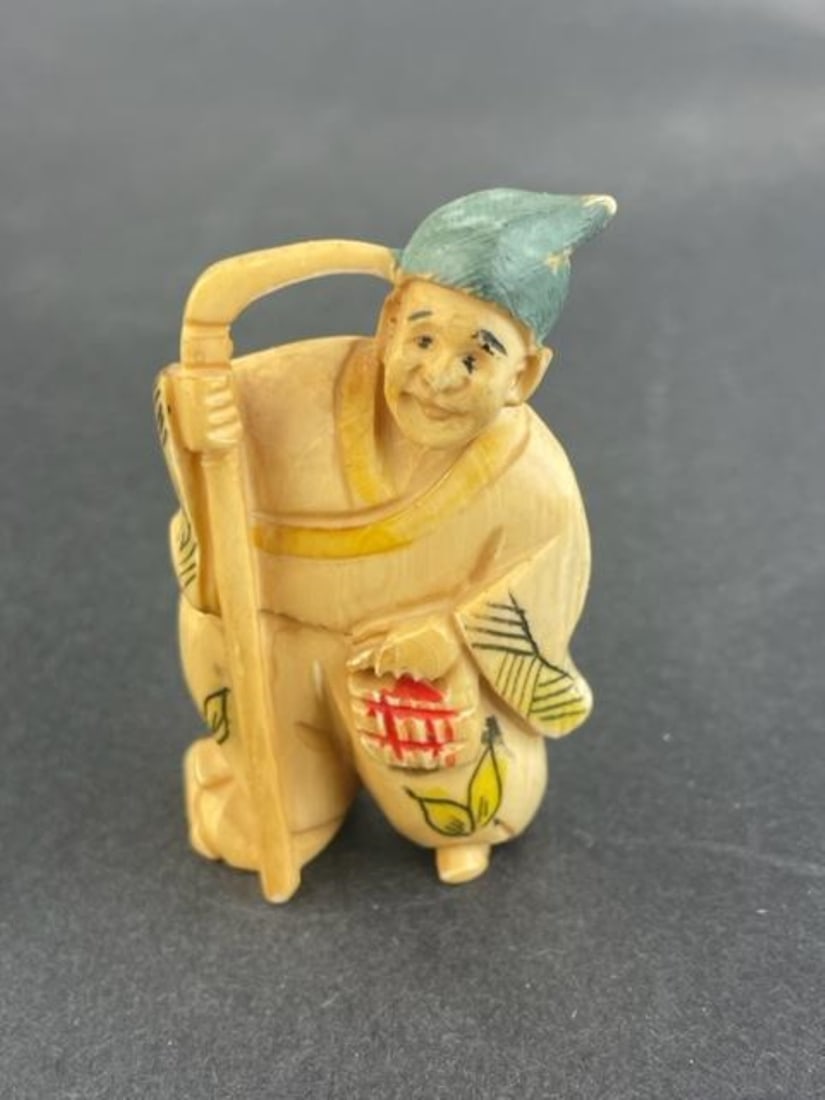 Antique Japanese carved netsuke of a man holding a sickle. (1 of 5)
