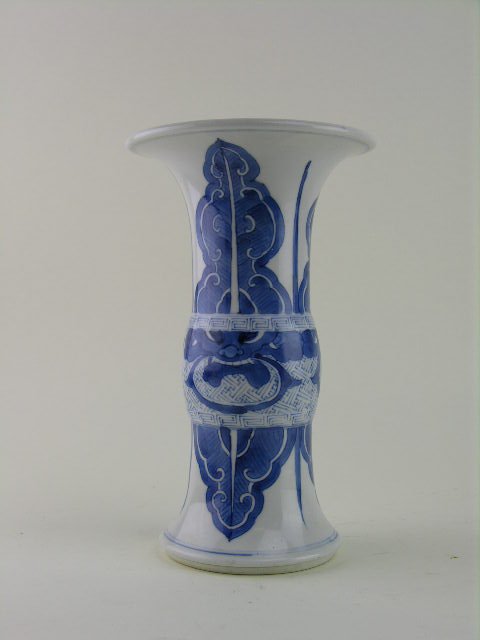 Chinese blue and white porcelain beaker vase, Kang: Chinese blue and white porcelain beaker vase, Kangxi period. Everted rim and foot with taotie masks to bulbous waist between leaf and fret work bands, double blue ring base. H: 9"