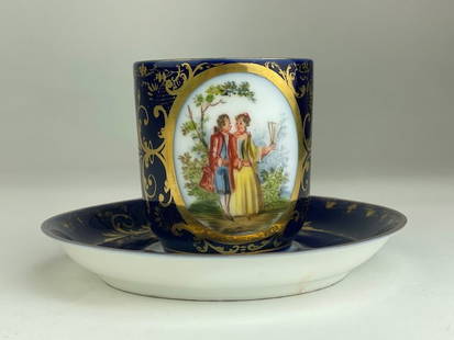 Royal Vienna porcelain demitasse cup with attached handle and matching saucer: Royal Vienna porcelain demitasse cup with attached handle and matching saucer, painted with romantic scenes on a cobalt blue ground and gold enamel.Marked with the Beehive Mark on the bottom of both p