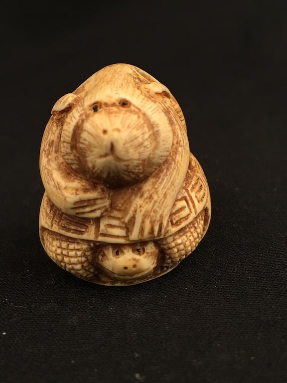 A carved Netsuke figure figure of an animal on the back of a turtle. (1 of 5)