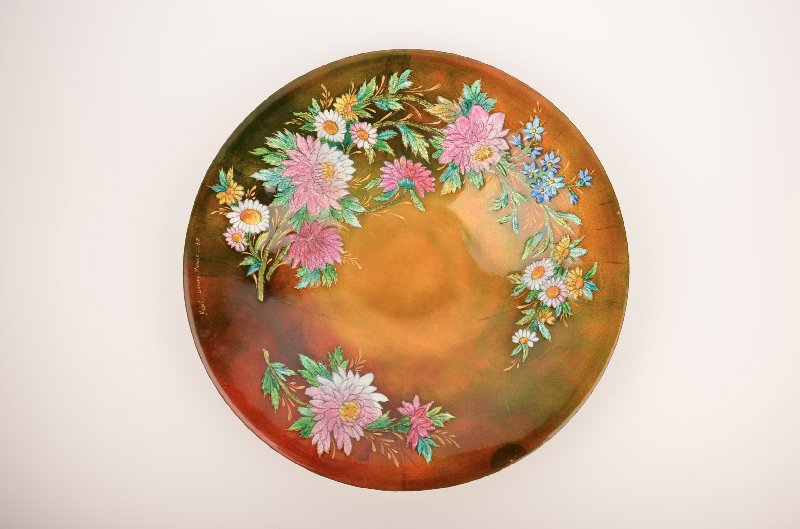 Camille Faure (French: 1874-1956) shallow bowl.: Camille Faure (French: 1874-1956) shallow bowl with flowers and leaves.Original paper label as well as signed Faure Limoges France. Diameter 11".(Some lines within the boarder).
