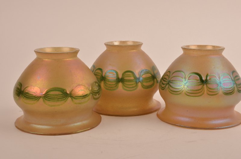 Three Loetz bell shapped shades decorated with a chain: Three Loetz bell shapped shades decorated with a chain around the missle circumference.Fitter 2 1/4". Height 3 3/4".(Some minor normal chipt to fitter, concealed when placed into lamp).