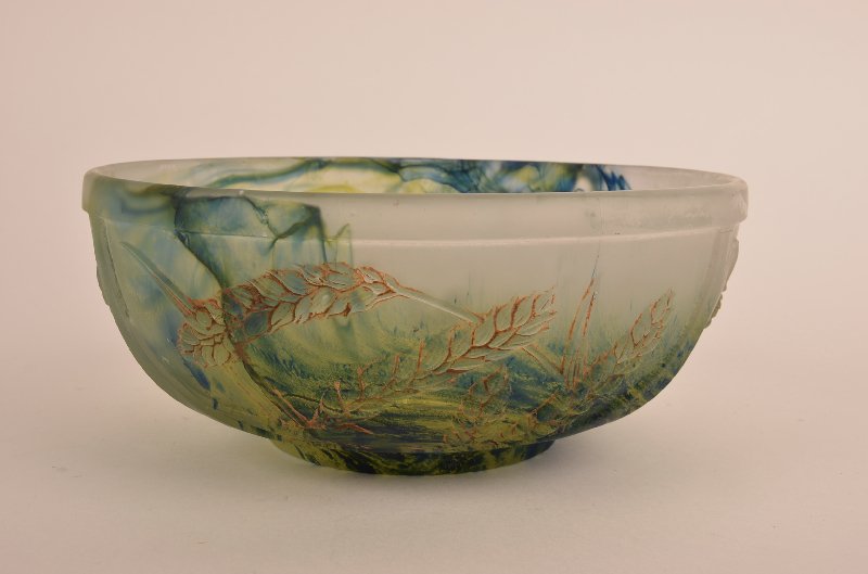 A Daum Nancy Pate de Verre bowl decorated with shafts: A Daum Nancy Pate de Verre bowl decorated with shafts of wheat all around with blue, yellow and green on a milky white ground.Diameter of rim 8". Height 3 1/2".