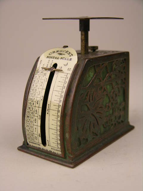 Tiffany Studios postage scale in the "Grapevine": Tiffany Studios postage scale in the "Grapevine" pattern with green colored glass and "Crescent" scale. Stamped "Tiffany Studios New York". Height 3". Circa 1910.