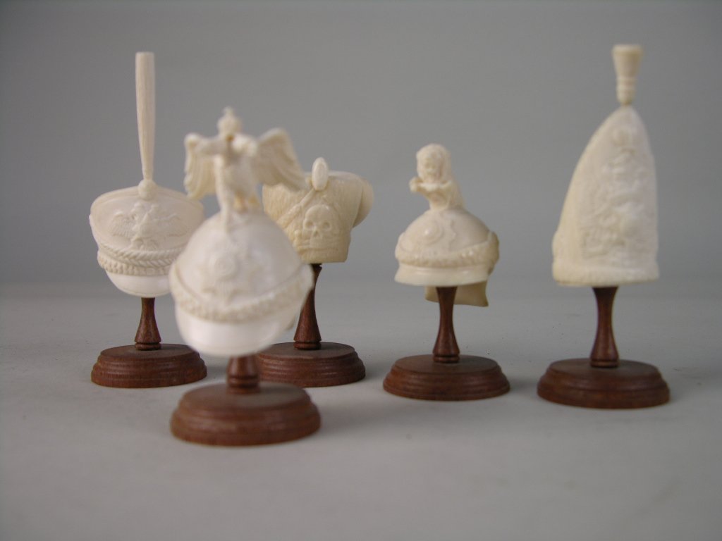 Set of 5 ivory carvings of Military helmets: Set of 5 ivory carvings of Military helmets. Tallest 3 1/2".