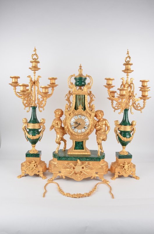 Three piece garniture set.: Three piece garniture set, center clockwith seven lights.Green marble with gold omulou mounts.Tallest piece 27 1/2 inches.