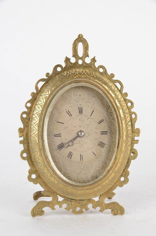 A strutt clock after those of Thomas Cole with a silver: A strutt clock after those of Thomas Cole with a silver face with a sub second hand dial with painted Roman numerals.The oval case is with a pierced brass front and a easle back.4 inches wide x 5 inch