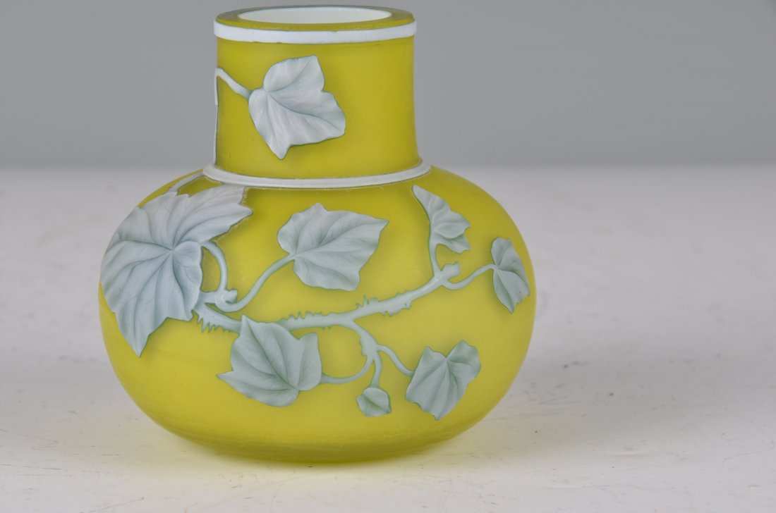 Attr: Thomas Webb Cameo Glass Vase. Cased glass vase: Thomas Webb Cameo Glass Vase, unsigned . Cased glass vase with a yellow ground, White cameo glass with a cut ivy leaf and vine pattern on one side with green to the edges. Height 3 1/2 inches.