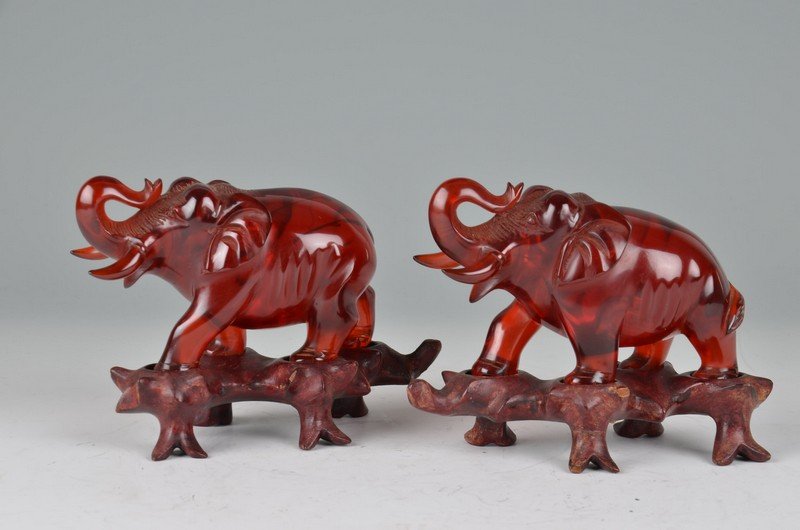 Pair of amber elephants with trunks up: Pair of amber elephants with trunks up. Mounted on wood bases. Height of figures 3 1/4 inches. Height with wood bases 4 1/4 inches.