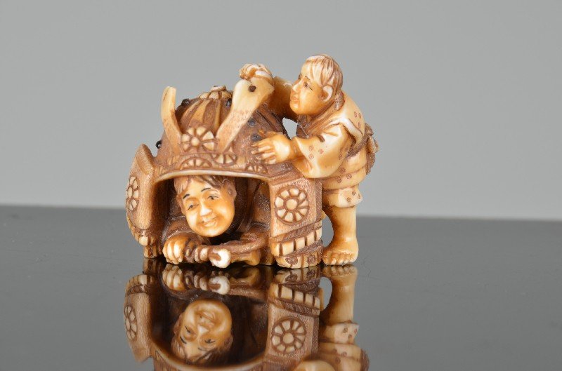 Japanese carved Netsuke of a young child hiding under a (1 of 5)