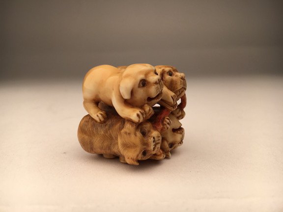 A carved Netsuke figure of four small dogs (1 of 3)