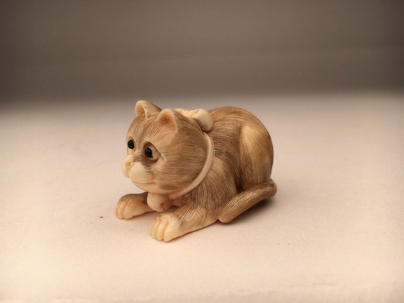 A carved Netsuke figure of a cat on all four paws. (1 of 4)