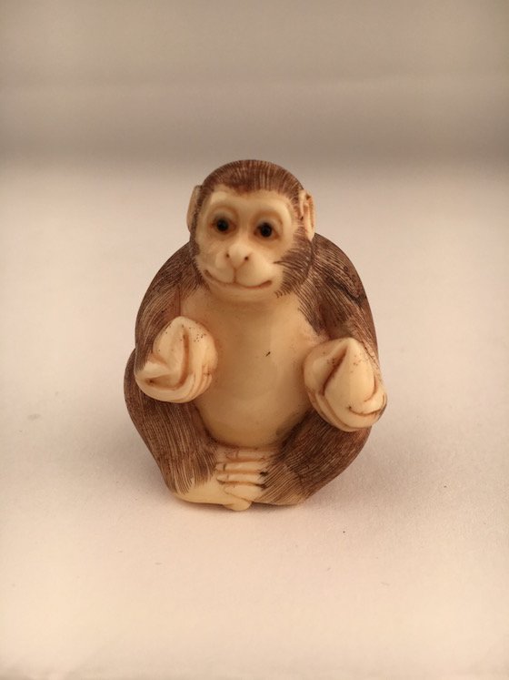 A carved Netsuke figure of a sitting monkey (1 of 4)