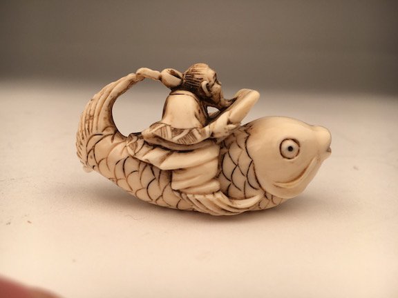 Carved Netsuke figure of a man ridding on a large fish. (1 of 3)