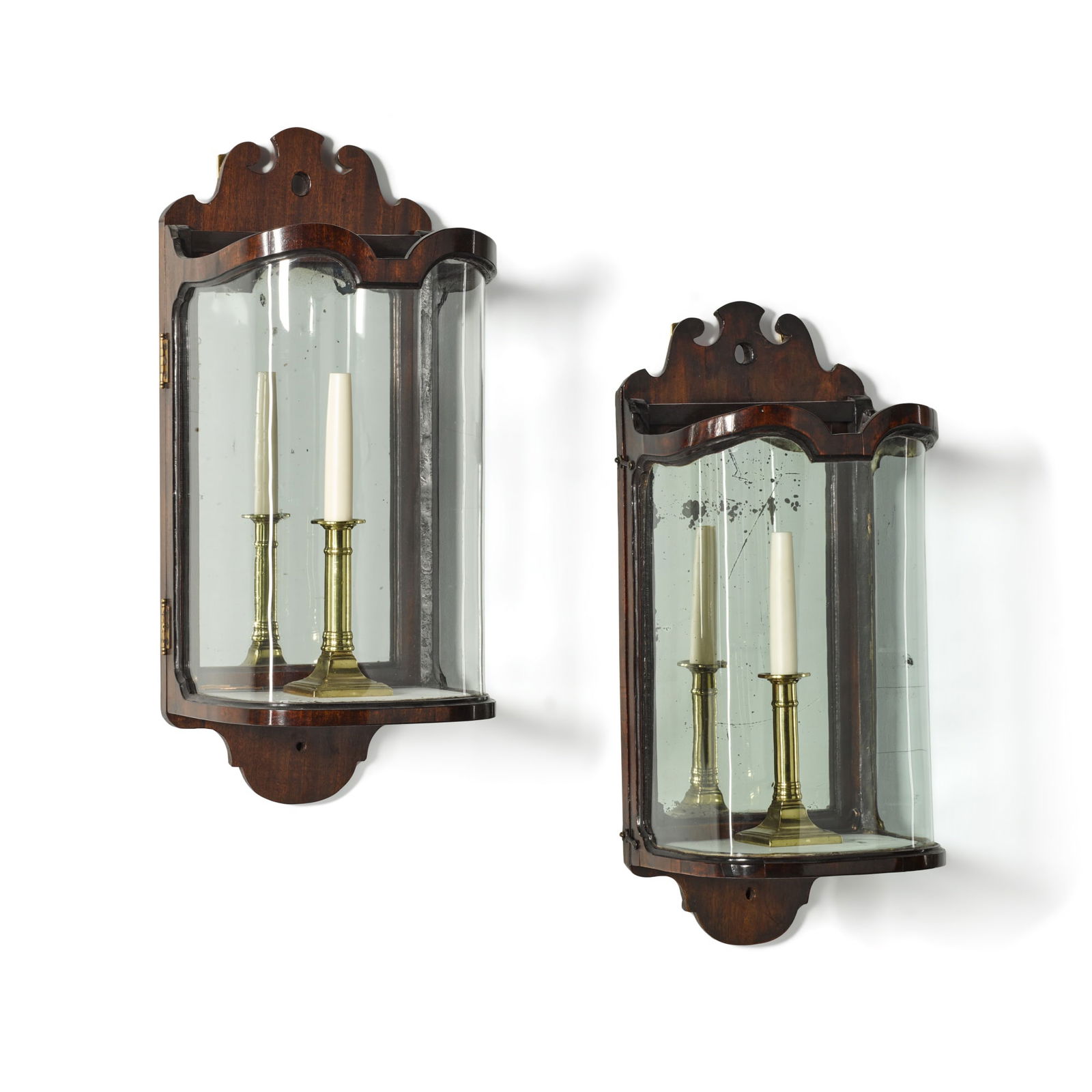 A George III mahogany, mirrored and glazed wall-lantern, circa 1760, together with a matching: A George III mahogany, mirrored and glazed wall-lantern, circa 1760, together with a matching lantern of later date the fret-carved crestings with arched mirrored backs, the hinged door with mo