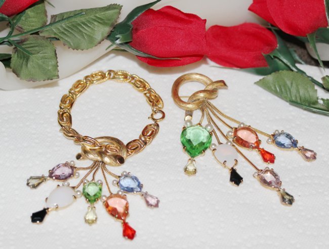 Elsa Schiaparelli Bracelet and Pin Demi Parure: Beautiful Demi Parure Bracelet and Pin set made and designed by Elsa Schiparelli, circa 1950s. The set is made of a gold tone metal with an off-set â€œKnotâ€ design with five prong-set multicol