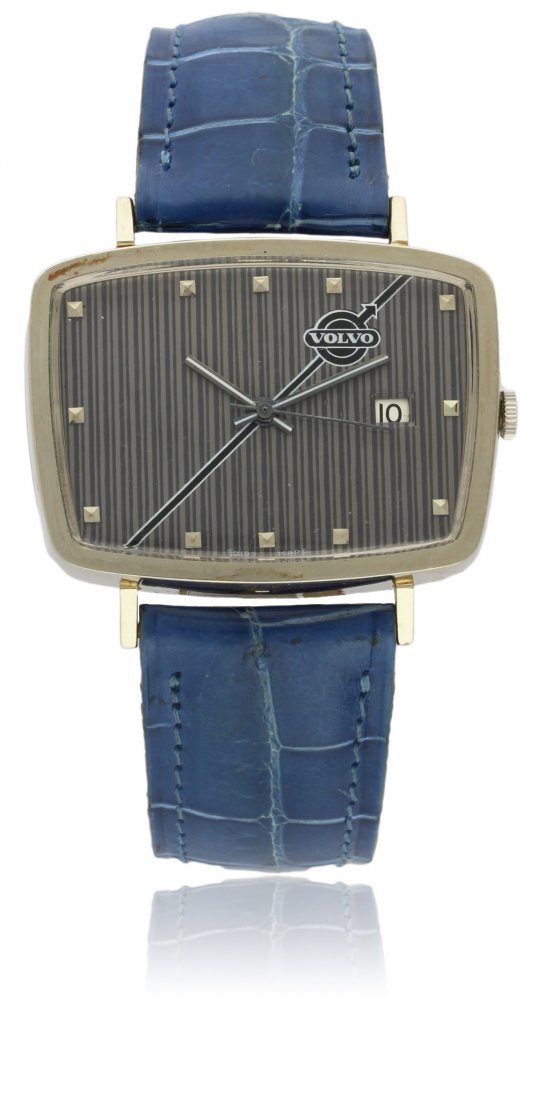 A RARE GENTLEMAN'S 18K SOLID WHITE GOLD BUECHE GIROD: A RARE GENTLEMAN'S 18K SOLID WHITE GOLD BUECHE GIROD VOLVO WRISTWATCH CIRCA 1960s D: Grey "pin stripe" dial with raised silver pyramid markers with the Volvo logo just below 11 o'clock, date aperture.