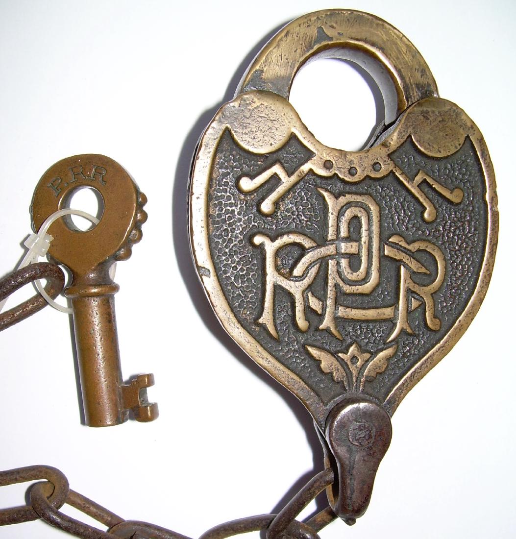 Pennsylvania Railroad Cast Back Lock & Key: An unusual Adams & Westlake made Pennsy cast back lock. It has the A&W oval logo at the top of the shackle on one side. The key has a "T" at 6:00 and a serial number of 2476.