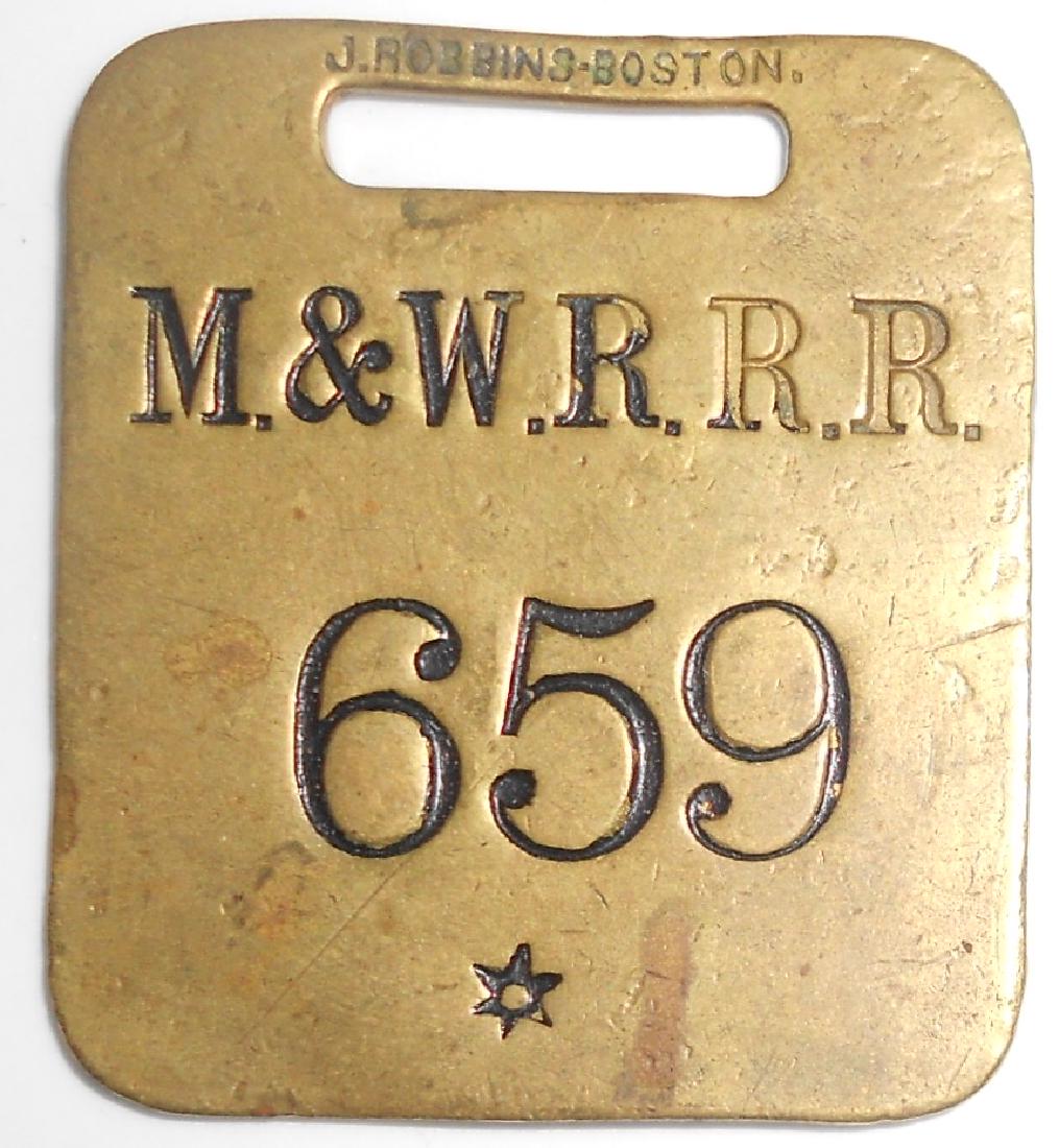 Montpelier & Wells River Railroad Baggage Tag: A brass baggage tag from the Vermont based Montpelier & Wells River Railroad. This is number 659 and it was made by john Robbins in Boston. The reverse is blank. Some slight discoloration.