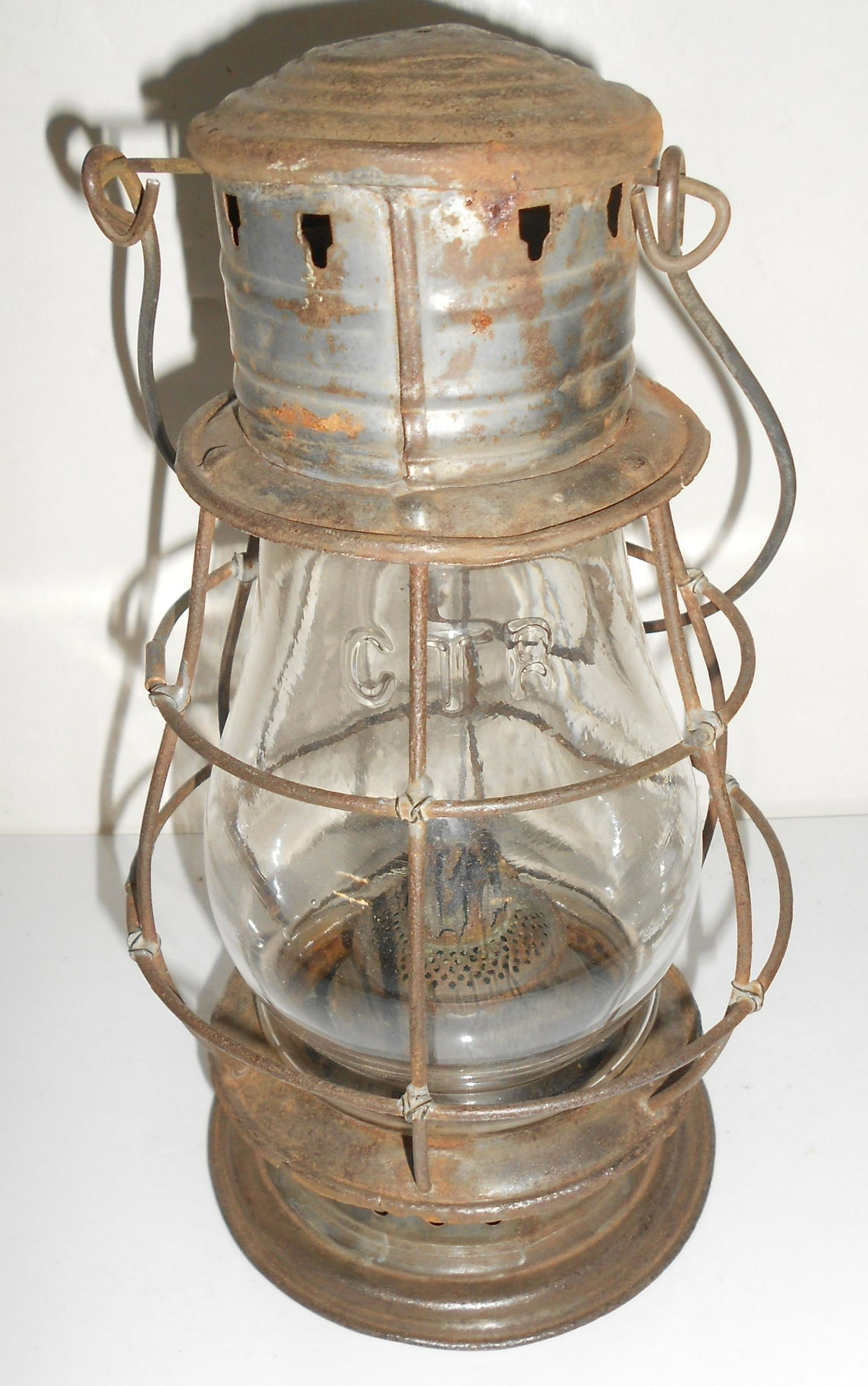 Grand Trunk Railroad Cast Fixed Globe Lantern: An early fixed globe lantern with a cast GTR globe. This frame pre-dates the use of wire clips. Note the soldered wire wraps at the wire joints and not clips. Very old tin work and a visible globe hei