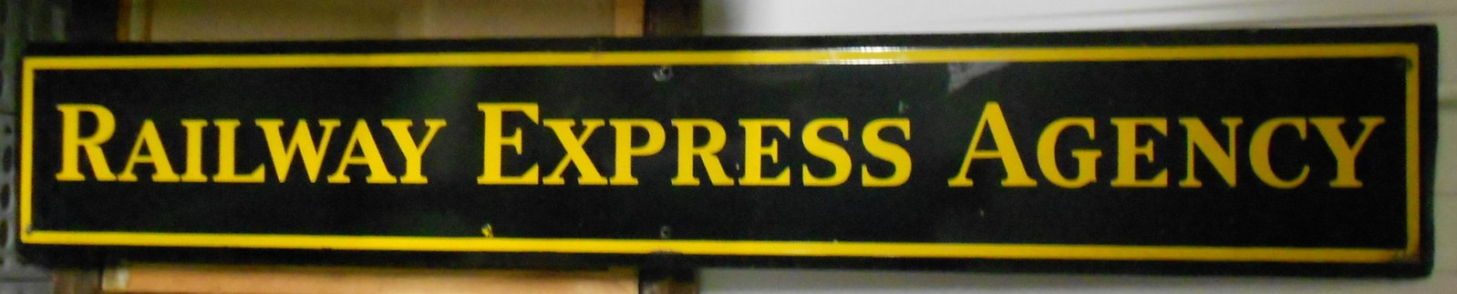 Railway Express Agency - Porcelain Sign - Black: A standard size Railway Express Agency porcelain sign measuring 72" by 12". This is the standard black & yellow version. It has some wear to the porcelain and reverse has rust.
