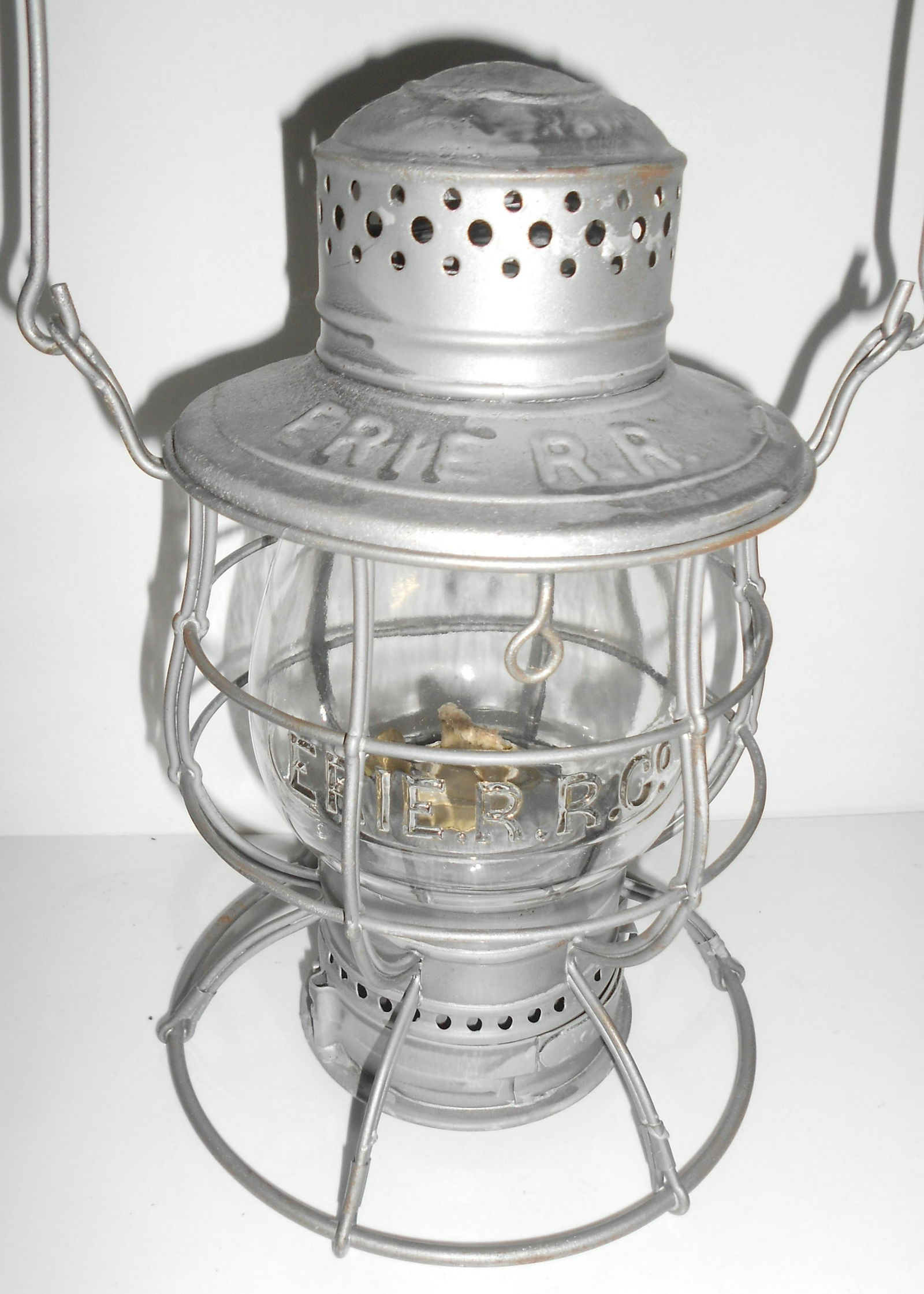 Erie Railroad Ham Lantern - Great EB Globe: An unusual globe in this C. T. Ham 1893 patent wire bottom frame. The frame has ERIE RR stamped in the lid and it has a twist off base and brass burner. This version has the odd double vertical wires