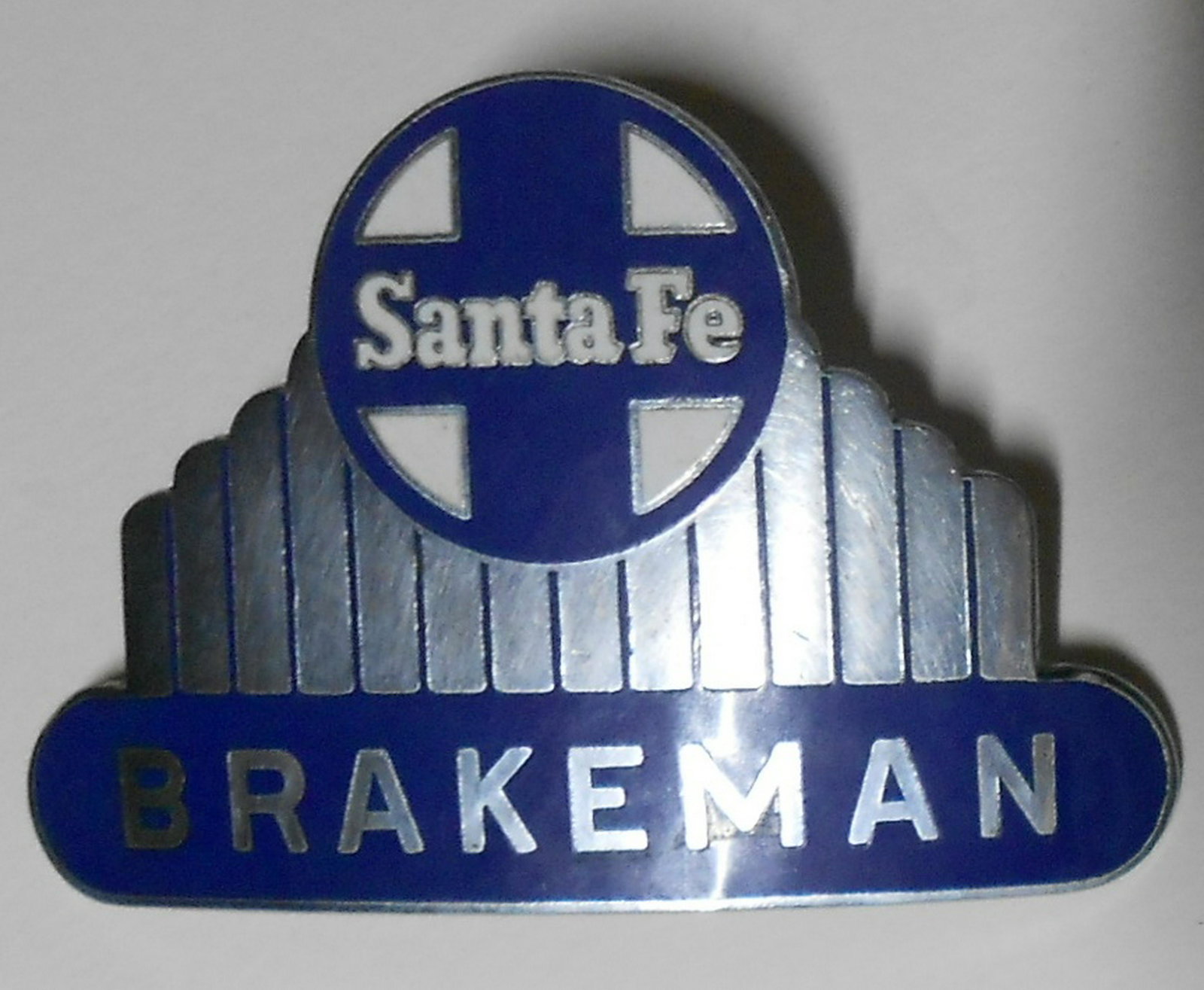 Santa Fe Railway Brakeman Hat Badge: Heavy enamel Santa Fe Railway Brakeman badge. All enamel intact. Reverse has treaded post and pin to keep it straight on a hat