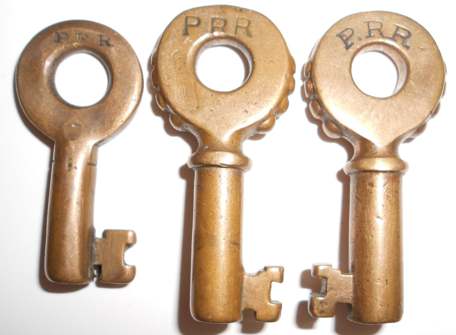 3 Pennsylvania Railroad Switch Keys - 2 Knobbys: A group of 3 switch keys from the Pennsylvania Railroad: (1) older PRR with single ring showing quite a bit of wear and "E" or "F" at 6:00 on the reverse (2) Knobby with PRR on the front and M 4597 on