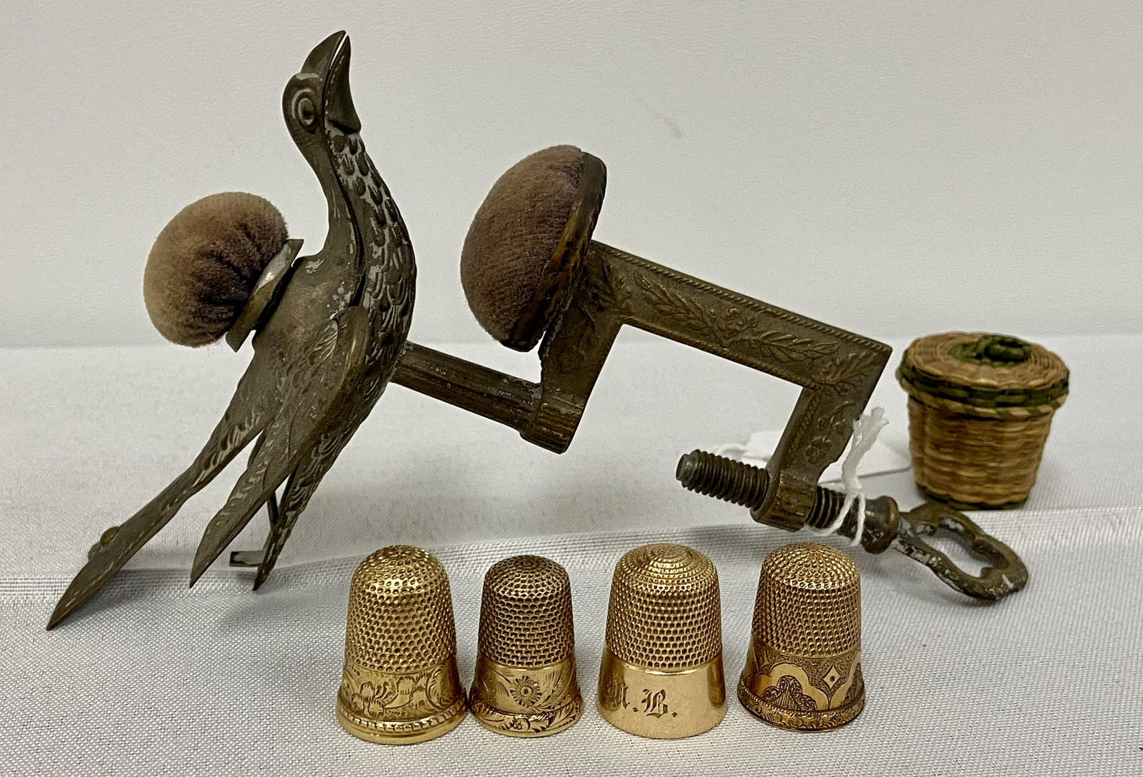 Victorian Sewing Bird & Gold Thimbles: Victorian Sewing Bird, complete w/original pin cushions, 4 gold Thimbles, 1 marked 14k, 1907, others unmarked, Woven thimble basket, good condition