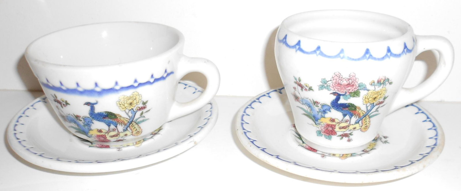 Milwaukee Road "Peacock" Cup & Saucer Sets: A pair of china cup & saucer sets from the Milwaukee Road in their "Peacock" pattern. All are Syracuse and have the Econo-Rim edge. The Dolphin cup has "Patented" on the bottom.