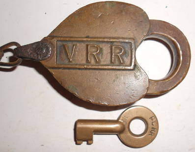 Vandalia Railroad Cast Panel Brass Lock & PC key: A Vandalia cast panel lock with VRR in large cast letters. No maker on the lock. The key is a later PCRR with the "big" bit. Dust cover has a strong spring. Keys works fine and is smooth with no wiggl