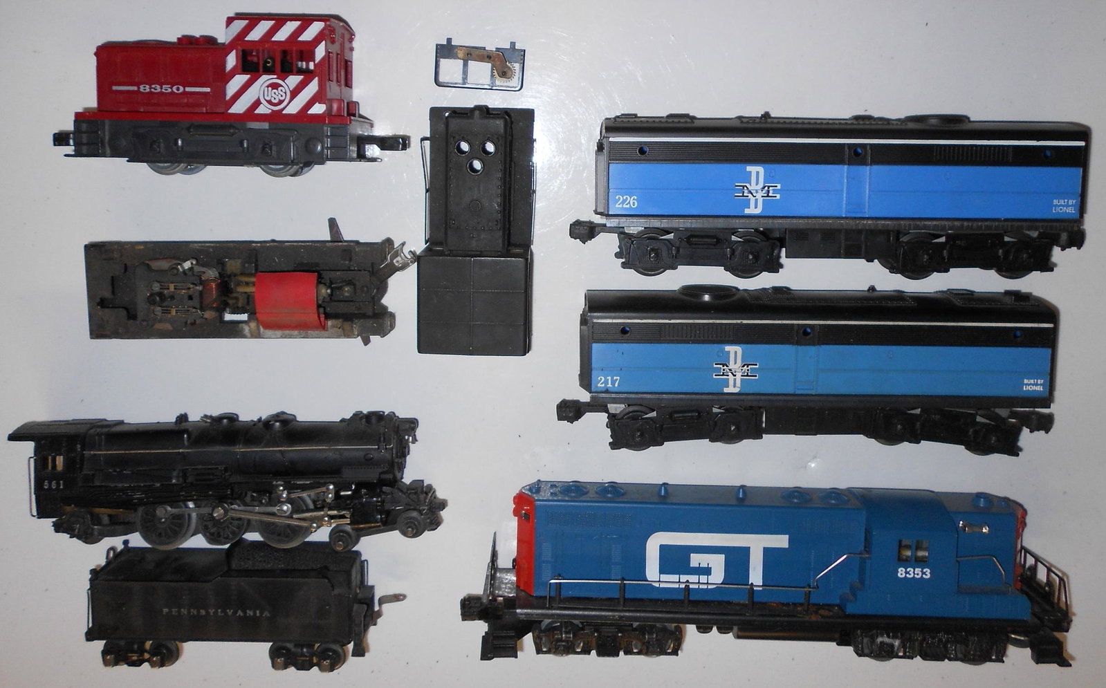 Lionel 027 561 & 8853 Locomotives: Lionel 027 locomotives that include a 561 Pennsylvania 4-6-2 and 2 0-4-0 industrial parts mechanisms & GTR 8353 diesel locomotive. No boxes, all untested.