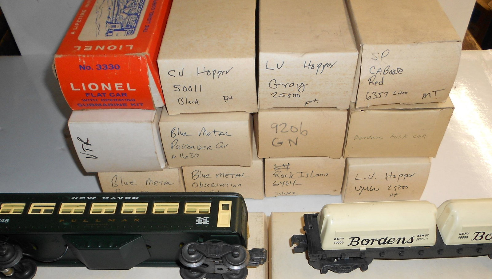 Lionel 14 Cars, some re-box, Submarine: Lionel 14 cars most with re-boxes. Some unusual cars with Pullman tin passengers and a Borden's Milk Car..
