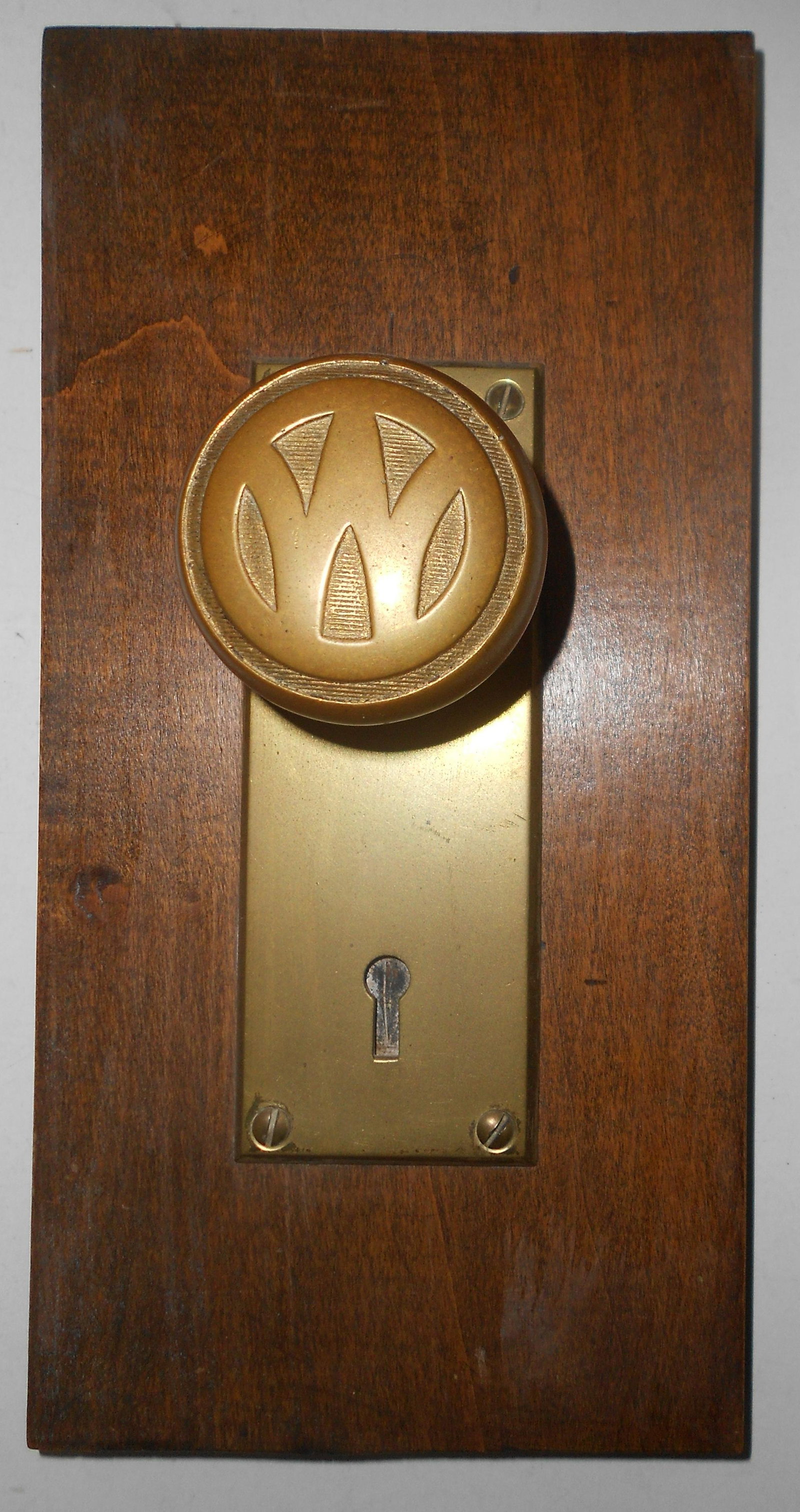 NYO&W Ry mounted Brass Doorknob - O&W logo: A nice New York Ontario & Western Railway brass doorknob mounted on a wooden board. Face plate measures 2 1/4" by 6". Board measures 5 1/4" by 10 1/2". The knob can be removed. The board has a hanging